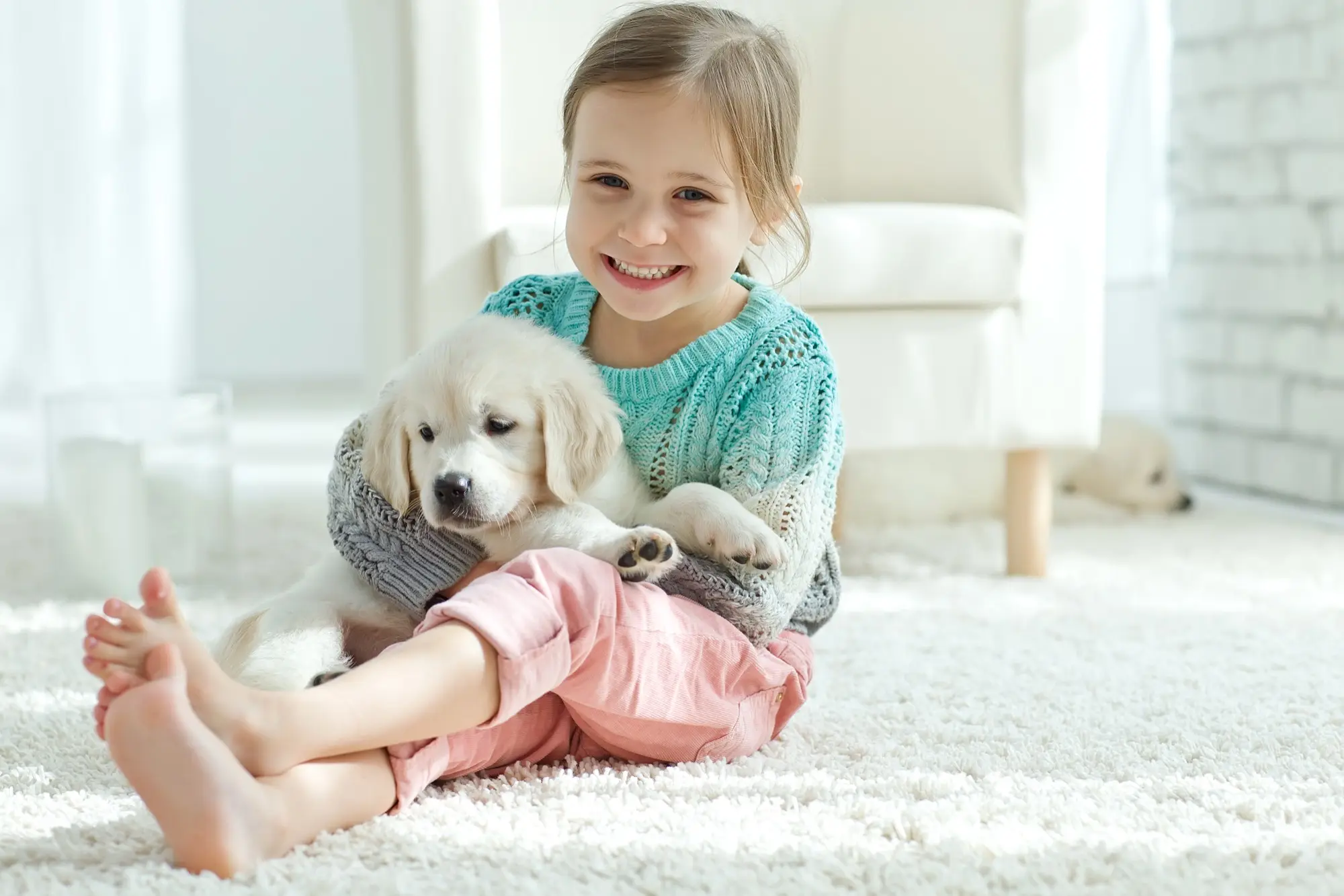 Petite fille souriante avec un chiot dans les bras